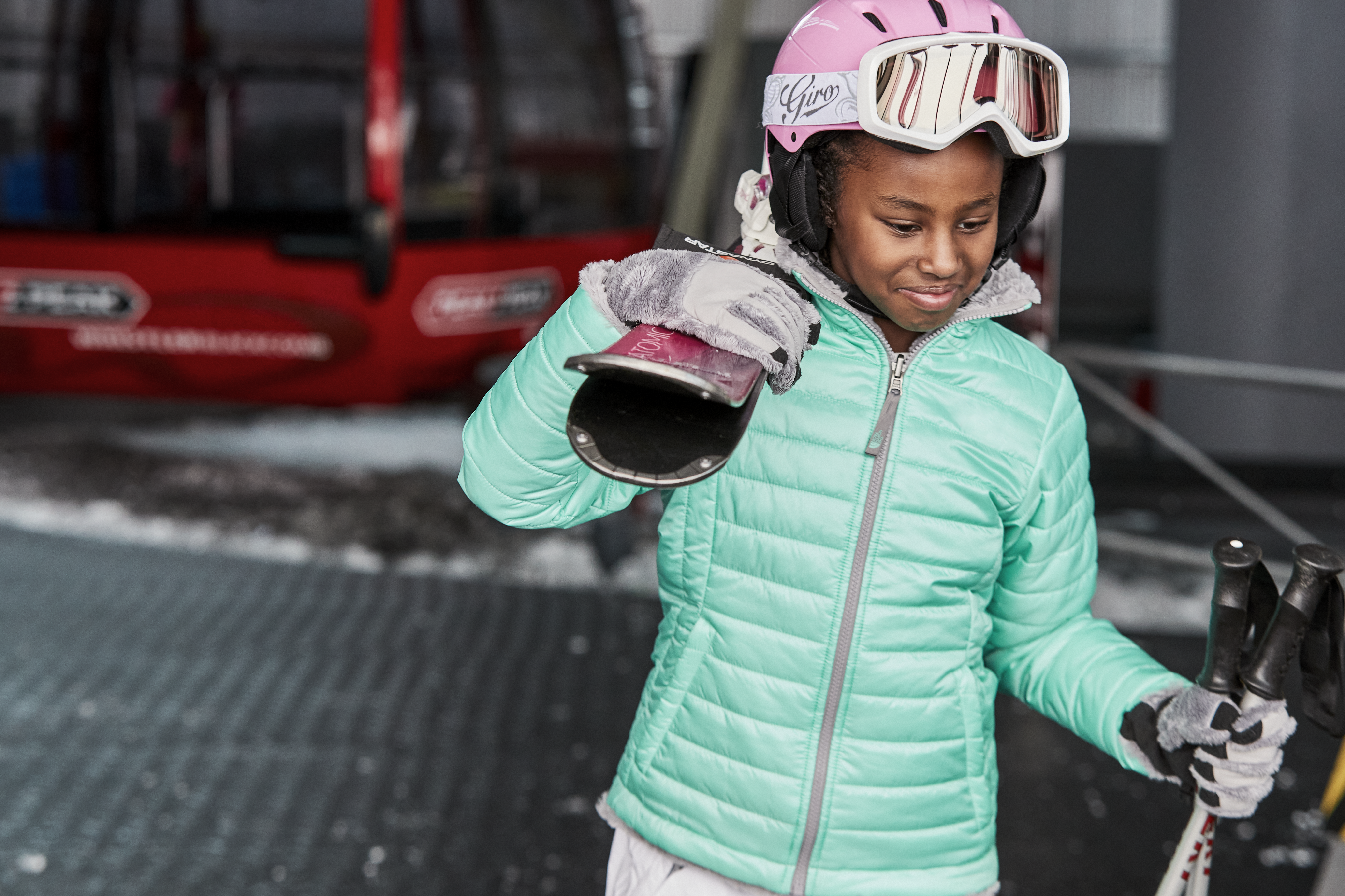girl smiling and holding skis
