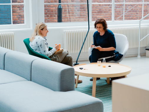 Two people talking at a coffee table