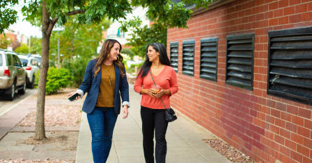 Two people walking on the street, talking
